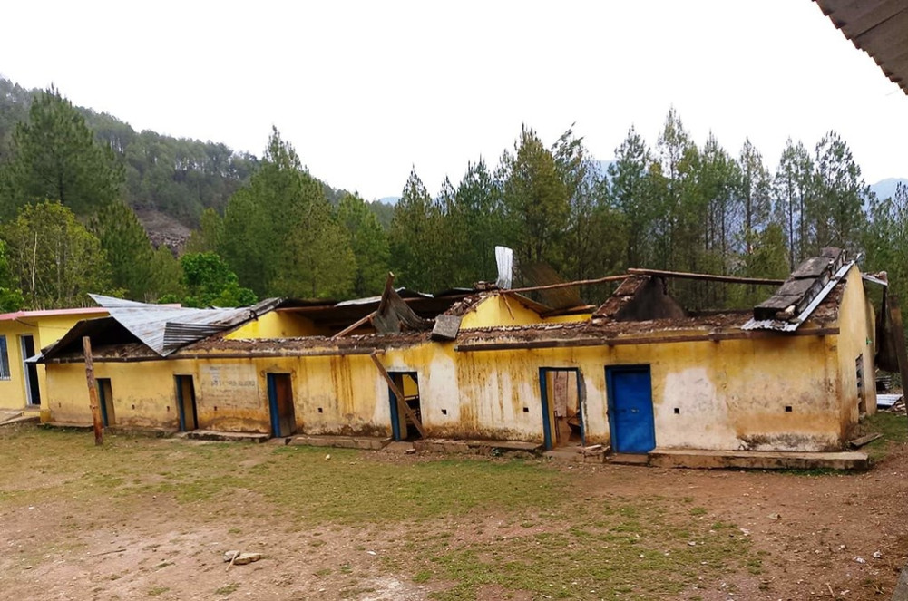 Three grade students study in the same room after a storm blew off their roof