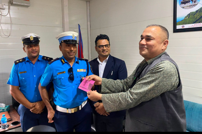 Traffic police hand over a chit to the Chief Minister of Sudurpaschim at his home